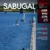 Embarcações à vela em água azul com pessoas a bordo, paisagem verde ao fundo e capa do Boletim Municipal de Sabugal.